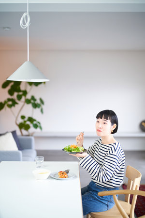young woman eating at home diningの写真素材