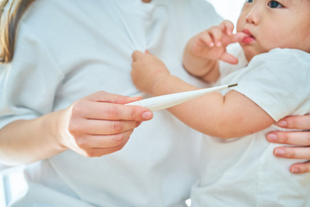 A little boy having his mother measure his temperature