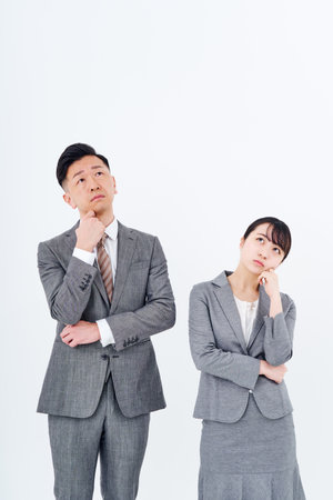 A man and woman in a suit who poses a question and white backgroundの写真素材