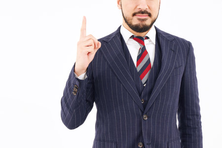 A man in a suit posing with his index finger up and white backgroundの写真素材