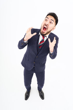 A man in a suit with a surprised expression and white backgroundの写真素材