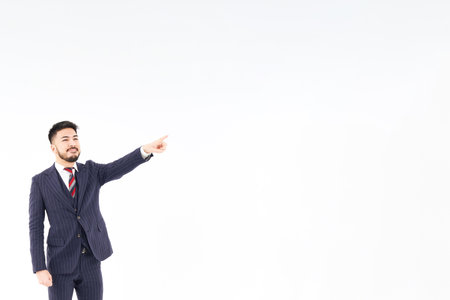 A man in a suit pointing up and white backgroundの写真素材