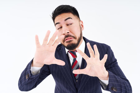 A man in a suit posing for refusal and white backgroundの写真素材