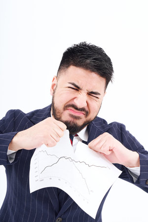 A man in a suit tearing up materials and white backgroundの写真素材