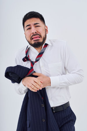 A man in a suit with a stressed expression with his clothes messed upの写真素材