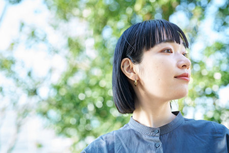 A woman with relaxed expression outdoorsの写真素材