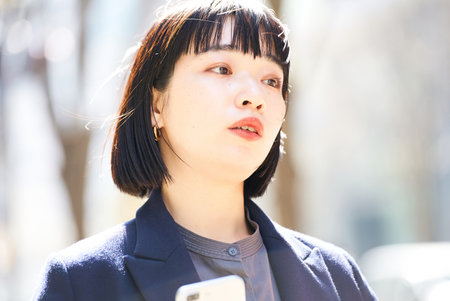 A young woman looking up at the sky (business woman)の写真素材