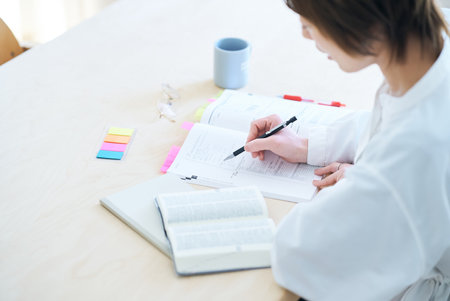 A woman in her thirties studying by text in the roomの写真素材