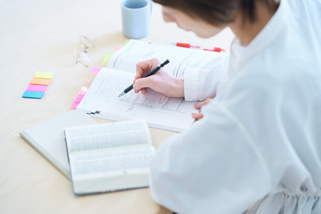 Woman's hand studying with text in the roomの写真素材