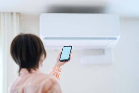 A woman holding a smartphone indoorsの写真素材