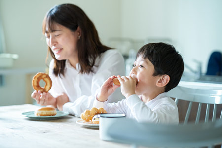 mother and son eating donut at homeの写真素材