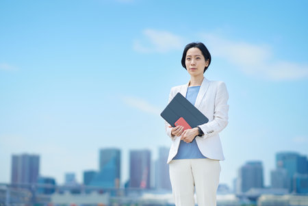 Business woman standing outdoors on fine dayの写真素材
