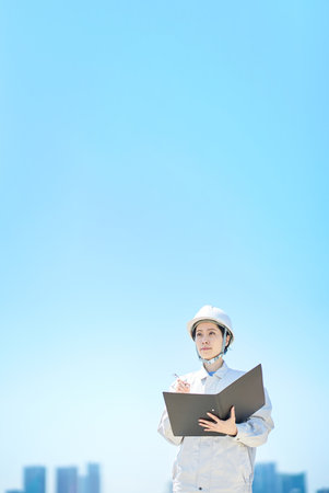 A woman in work clothes checking the site on fine day