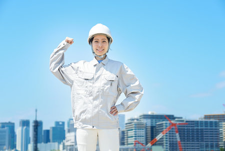 A woman in work clothes doing a positive pose on fine day