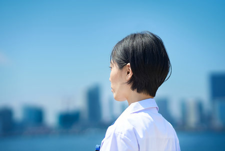 Back view of a woman in a white coat on fine dayの写真素材