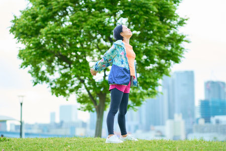 Asian woman exercising on urban green spaceの写真素材