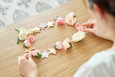 A woman's hands making a frame with flower-shaped and star-shaped accessoriesの写真素材