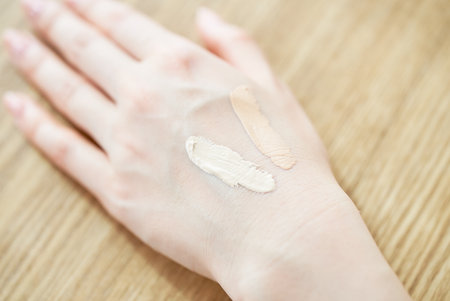 A woman's hand checking the color of the foundation
