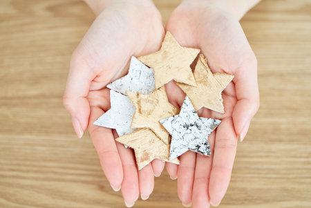 A woman's hands holding a star-shaped accessory on the tableの写真素材