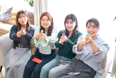Four young women excited with crackersの写真素材