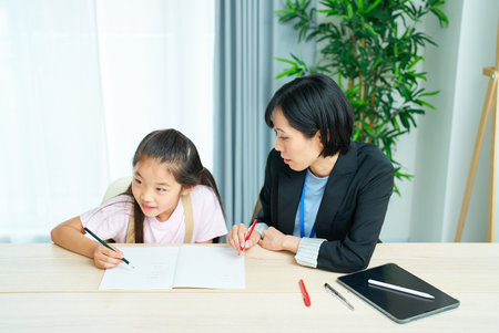 A girl studying and a woman in a suit to support in the room