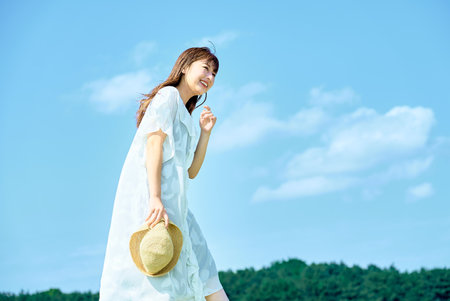 A young woman showing a relaxed expression under the clear skyの写真素材