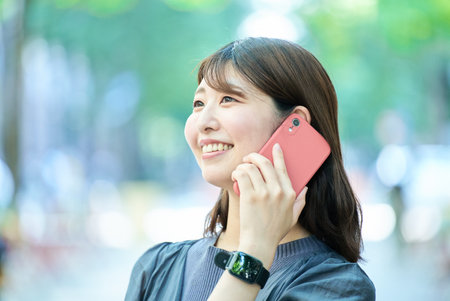 Young woman talking on smartphone outdoorsの写真素材