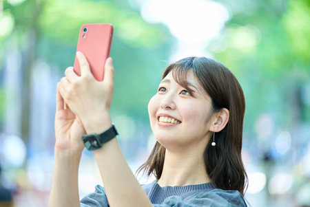 young woman holding a smartphone outdoors