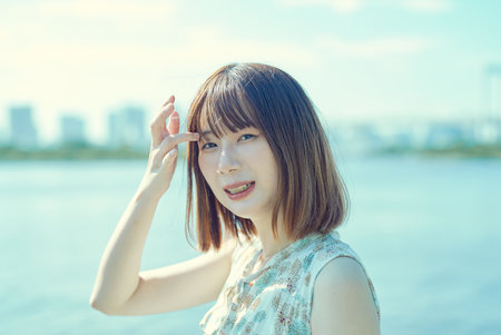 portrait of woman by the water on fine dayの写真素材