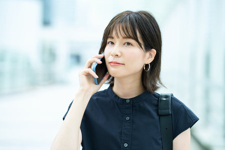 Young woman talking on smartphone outdoorsの写真素材