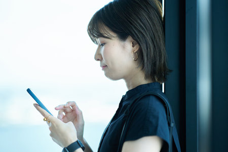 asian young woman holding a smartphoneの写真素材