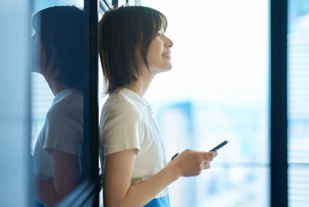 asian young woman holding a smartphoneの写真素材