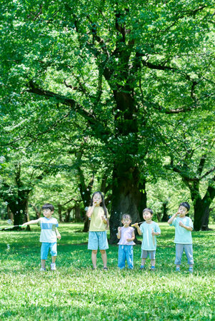Children playing with soap bubbles at the parkの写真素材