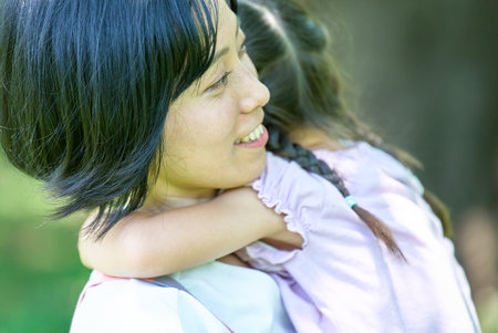 young woman holding a child with a smileの写真素材