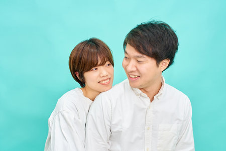 man and woman in a friendly atmosphere in front of blue backgroundの写真素材