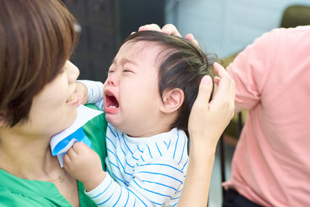 Crying baby and parents holding each other