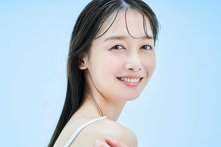 Asian young woman and light blue backgroundの写真素材