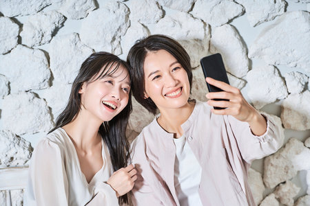 Two women looking at smartphone screenの写真素材