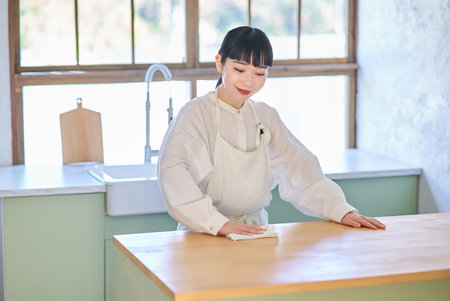 Young woman wiping and cleaning the roomの写真素材