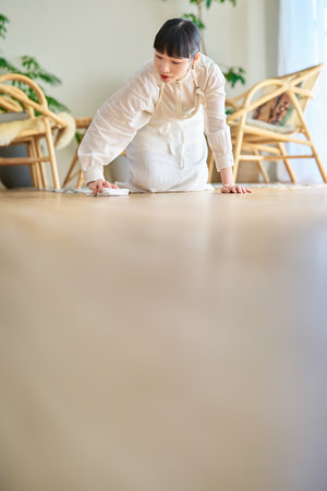 Young woman wiping and cleaning the roomの写真素材