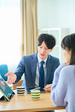 A man in a suit talking to a woman in the roomの写真素材