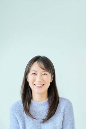 smiling young woman and white background in the roomの写真素材