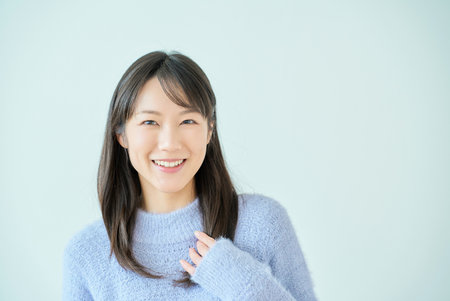 smiling young woman and white background in the roomの写真素材