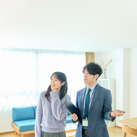 A man in a suit explaining the room to a womanの写真素材
