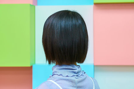 Back view of a beautiful black-haired woman and colorful backgroundの写真素材
