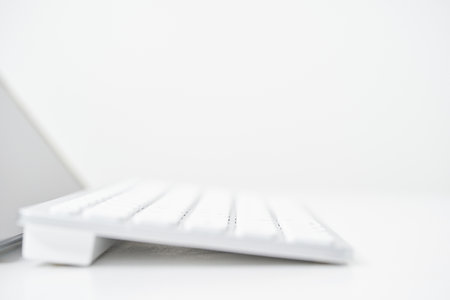 Close-up of wireless keyboard from the side on a white tableの写真素材