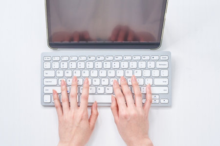 Hands of a woman typing on a keyboardの写真素材
