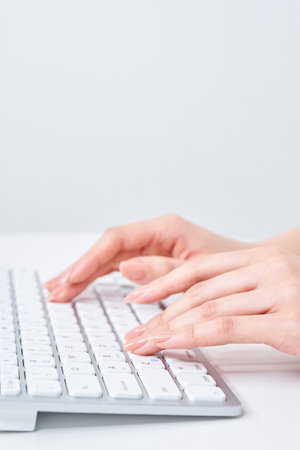 Hands of a woman typing on a keyboardの写真素材