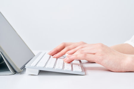 Hands of a woman typing on a keyboardの写真素材