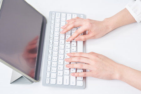 Hands of a woman typing on a keyboardの写真素材
